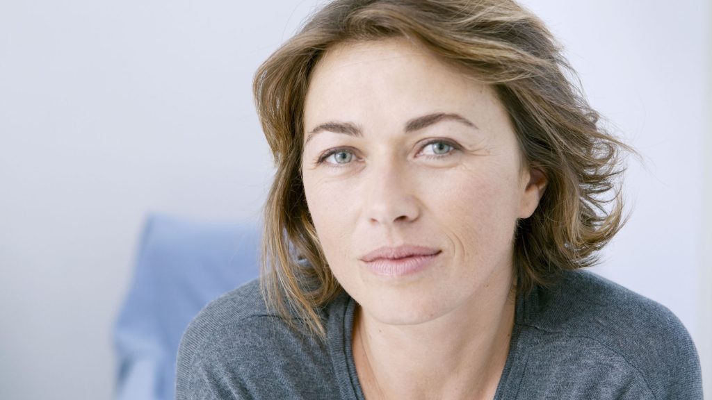 Een vrouw kijkt rustig en zelfverzekerd in de camera